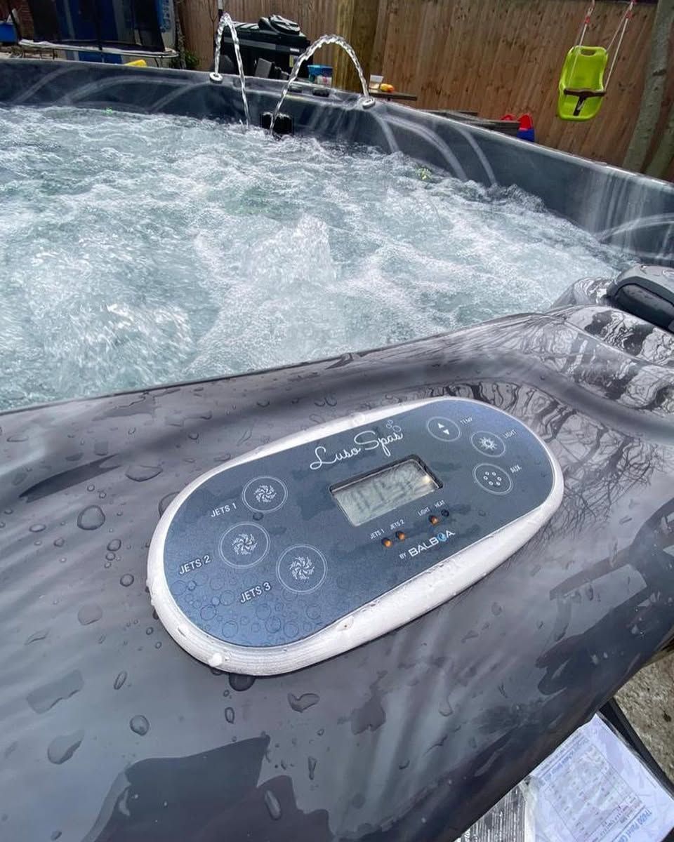 Hot tub control panel with digital display; bubbles in the water.