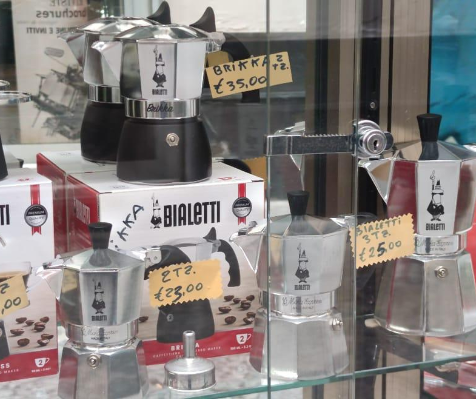 Vetrina di un negozio con esposizione di caffettiere da piano cottura Bialetti e cartellini dei prezzi.