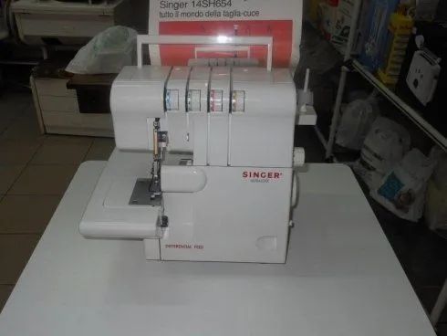 Macchina da cucire overlock Singer bianca su un tavolo in un negozio.