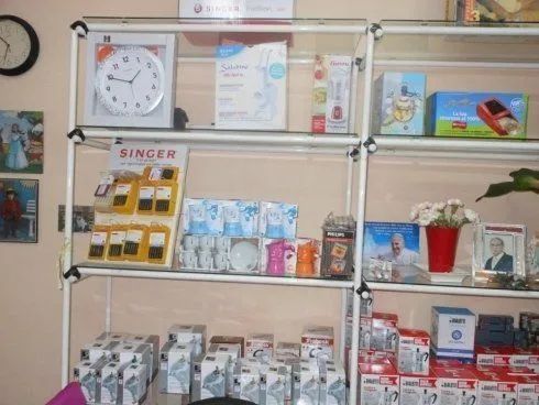 Scaffali del negozio con un assortimento di piccole scatole, bottiglie e prodotti colorati in mostra.