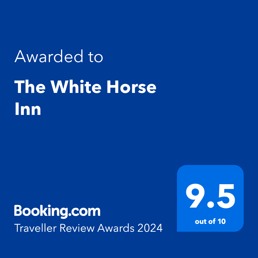 A blue sign that says ' awarded to the white horse inn ' on it