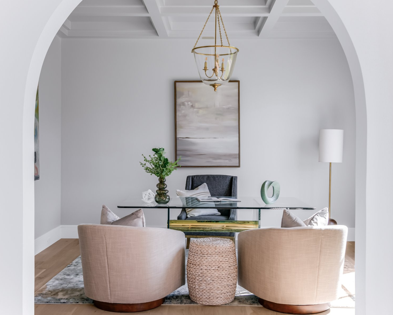 Interior of a home office with desk, two armchairs, and a neutral color palette.