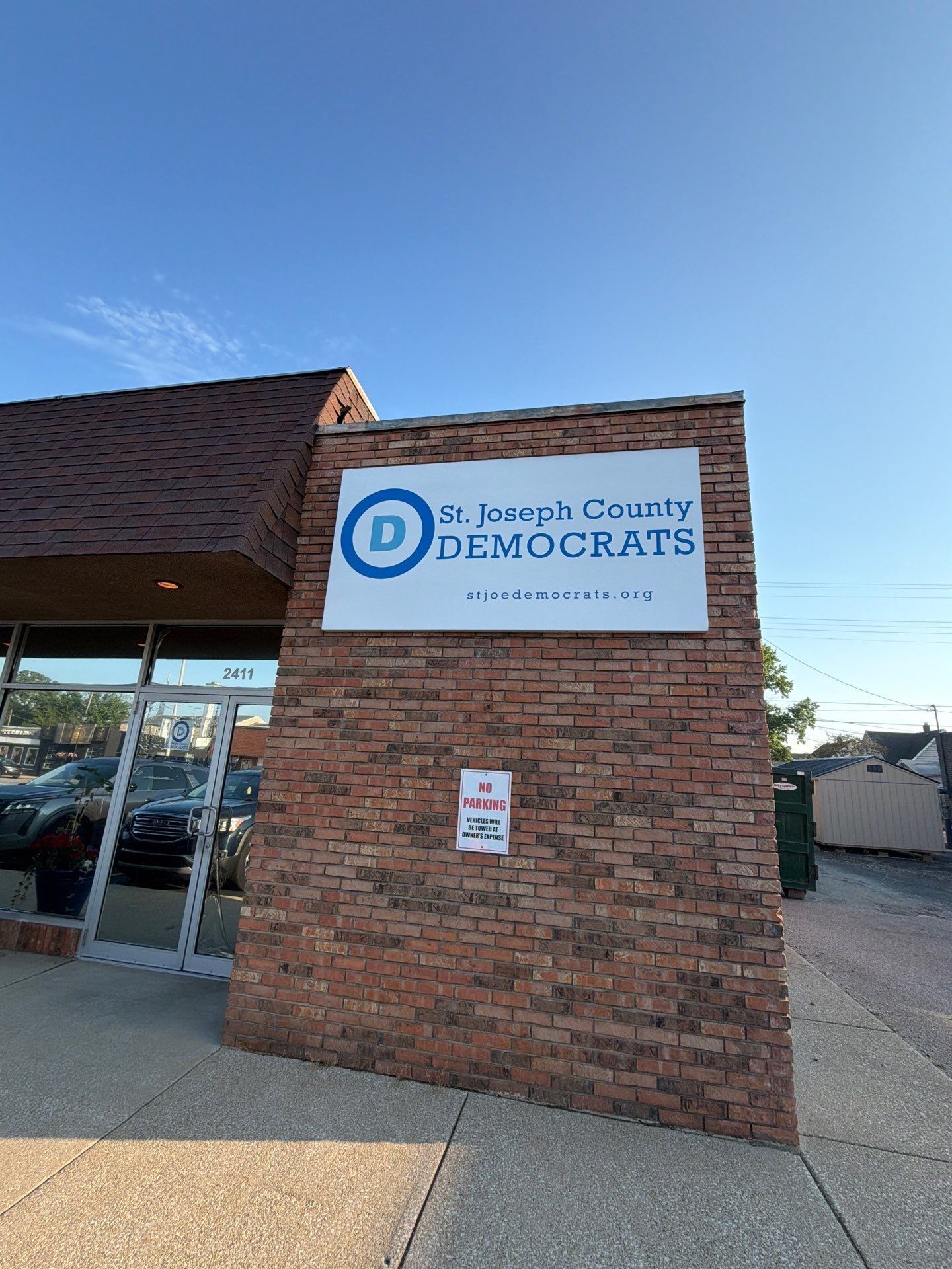 Brick building with a Democrats office sign under a clear blue sky