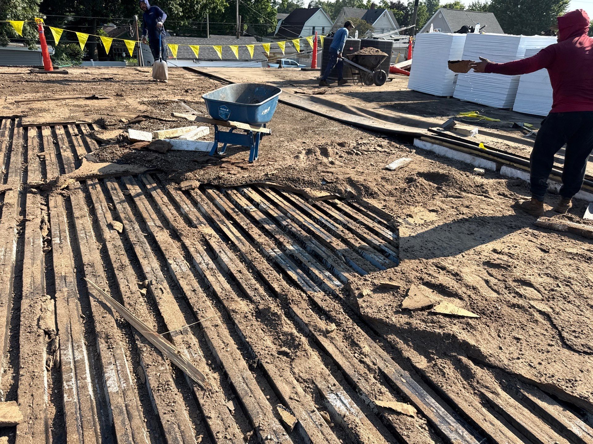 Construction site with rebar grid in dirt and workers in the background