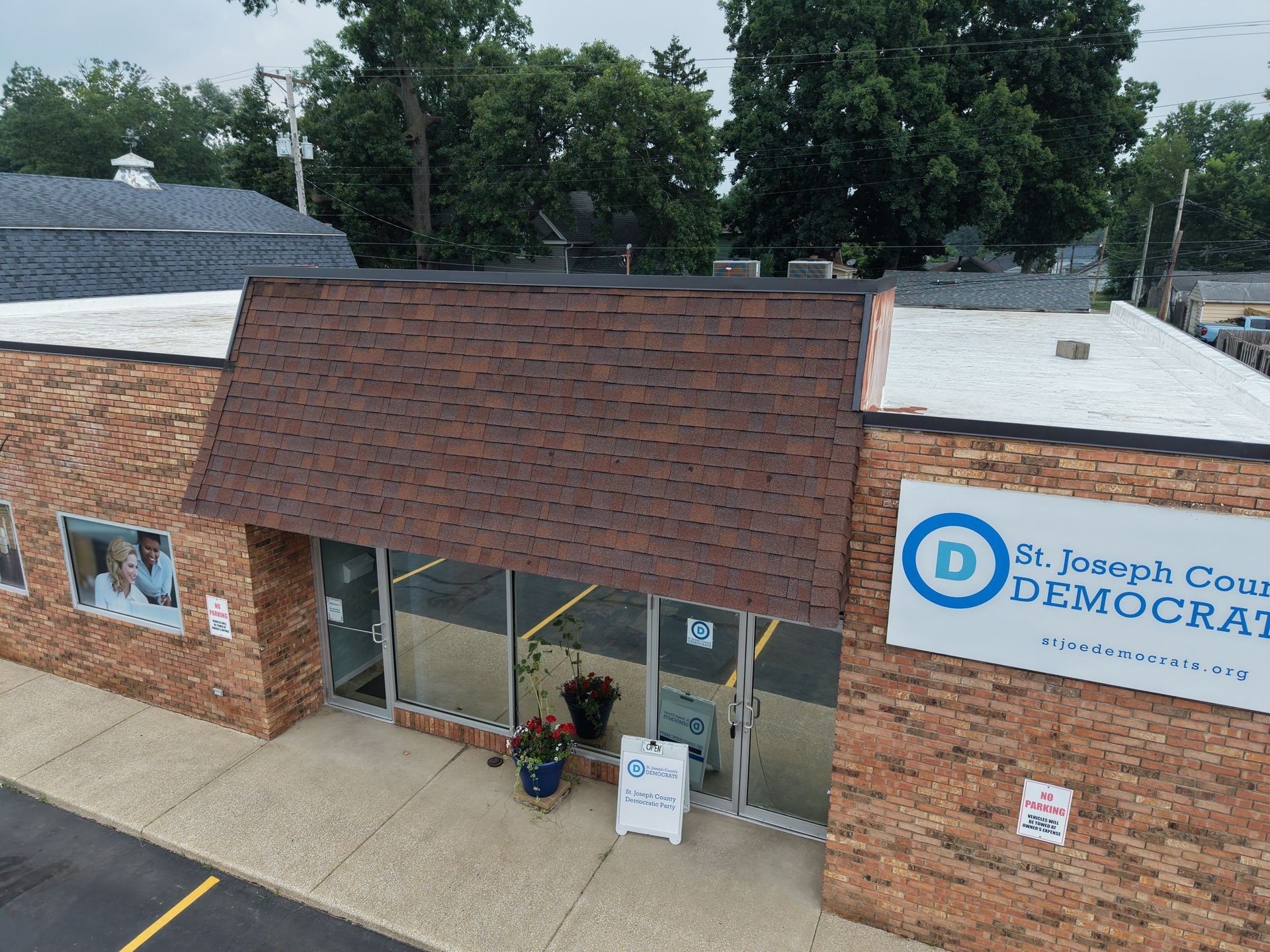 Brick storefront with brown awning and Democratic sign, viewed from above