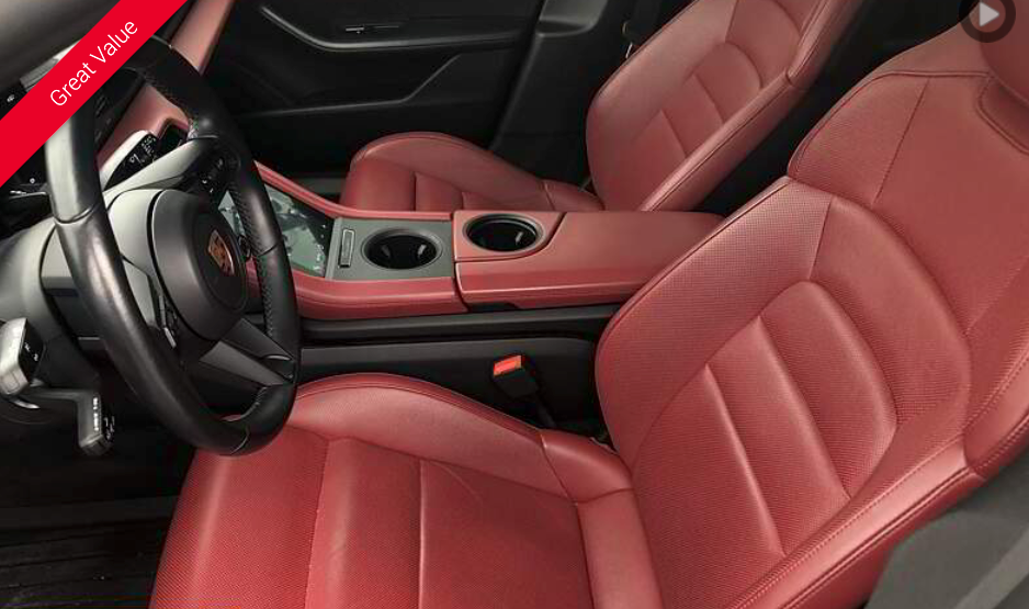 Red leather car interior with steering wheel, seats, and console.