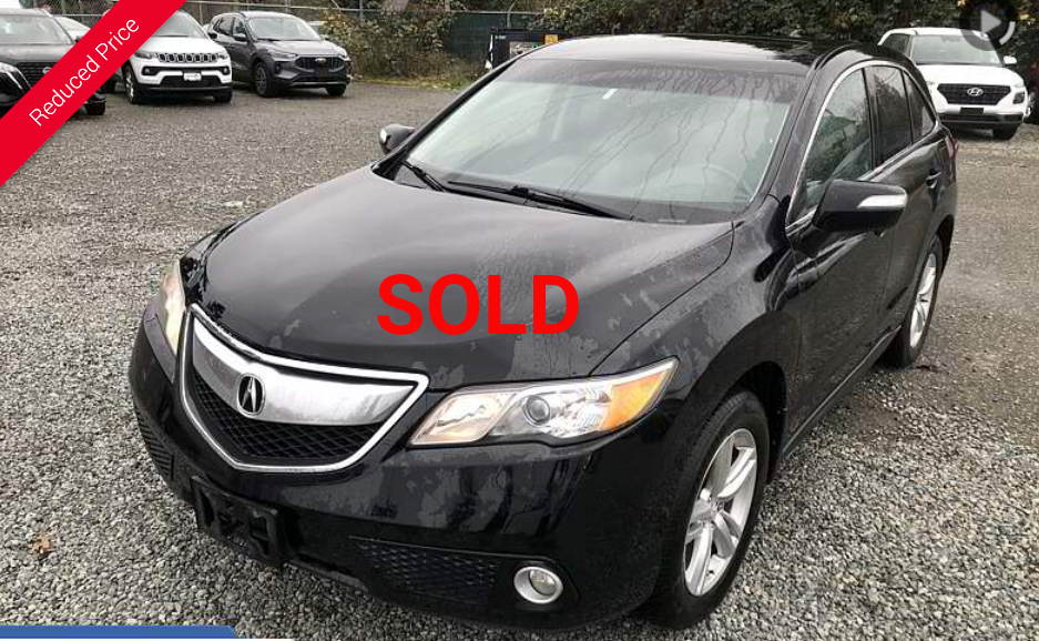 Black Acura RDX SUV parked on gravel, with 