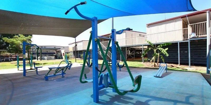 A Playground With A Blue Awning And Exercise Equipment — Leichhardt Accommodation in Mornington, QLD
