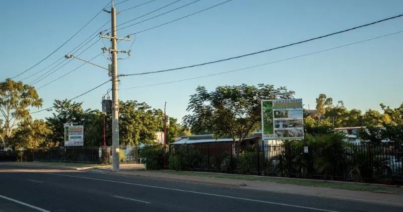 A Street With A Lot Of Power Lines And A Sign On The Side Of The Road — Leichhardt Accommodation in Mornington, QLD