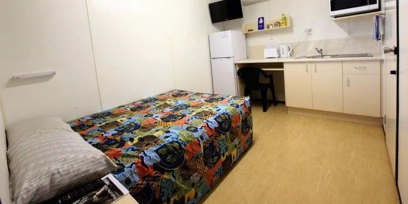 A Bedroom With A Bed, Desk, Refrigerator And Microwave — Leichhardt Accommodation in Mornington, QLD