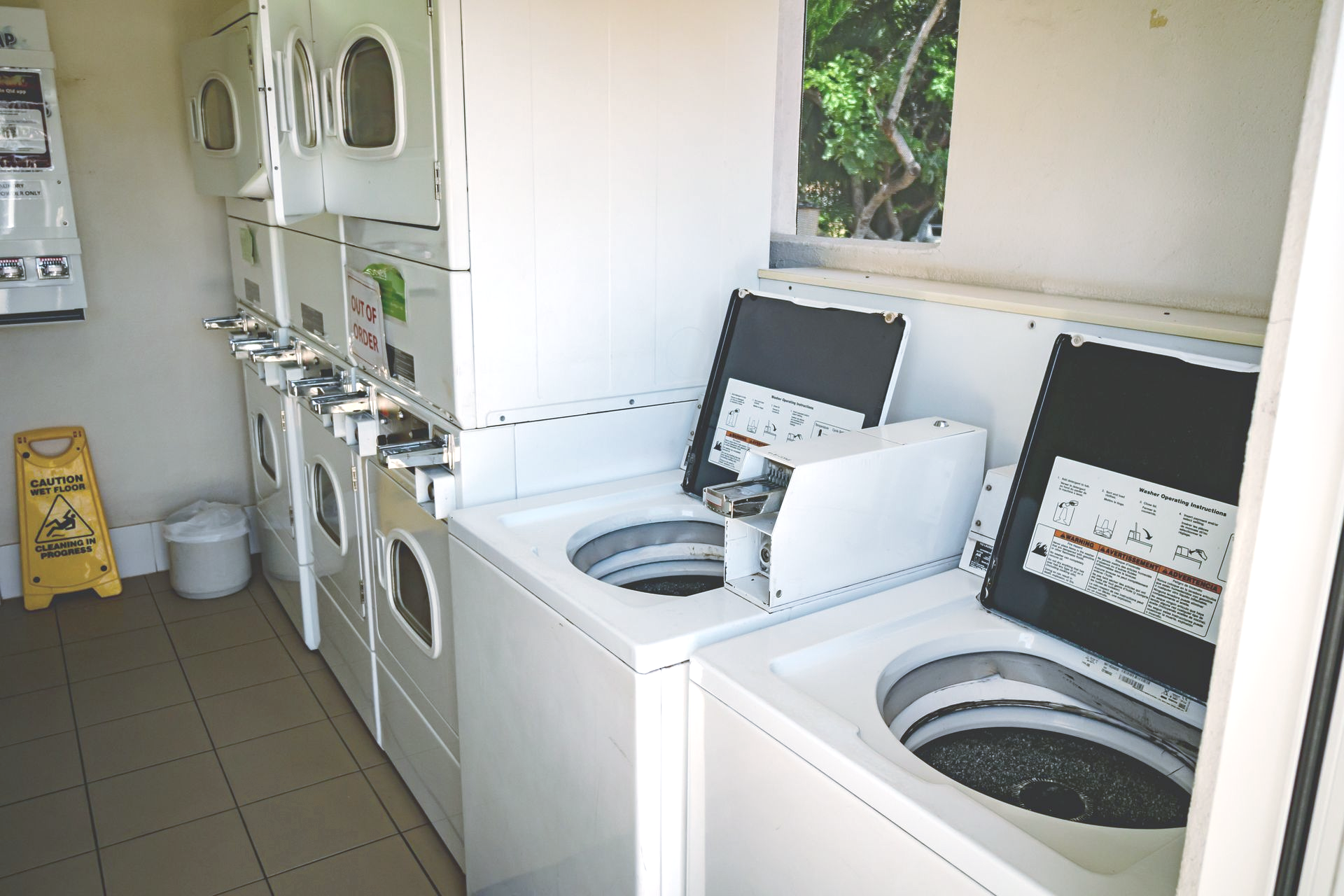 Row of White Washing Machines with Glass Doors on Display — Leichhardt Accommodation in Mornington, QLD