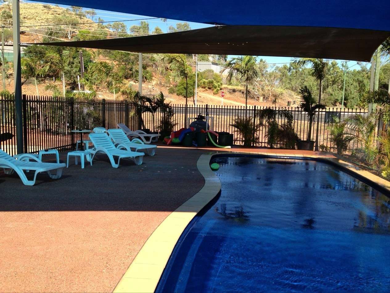 Swimming Pool with Lounge Chairs Under a Shade Sail — Leichhardt Accommodation in Mornington, QLD