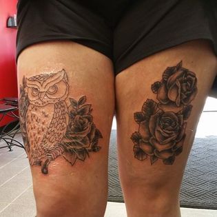 A woman has a tattoo of an owl and roses on her thighs.