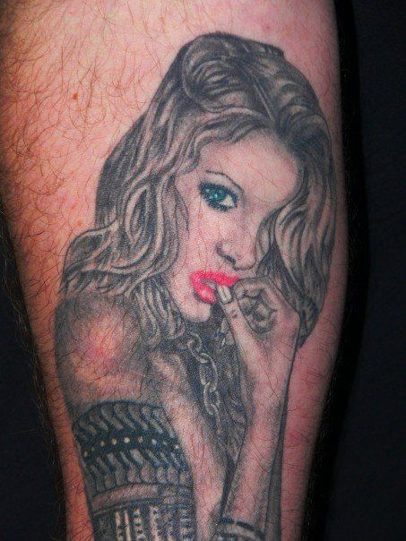 A man has a tattoo of a woman on his leg.