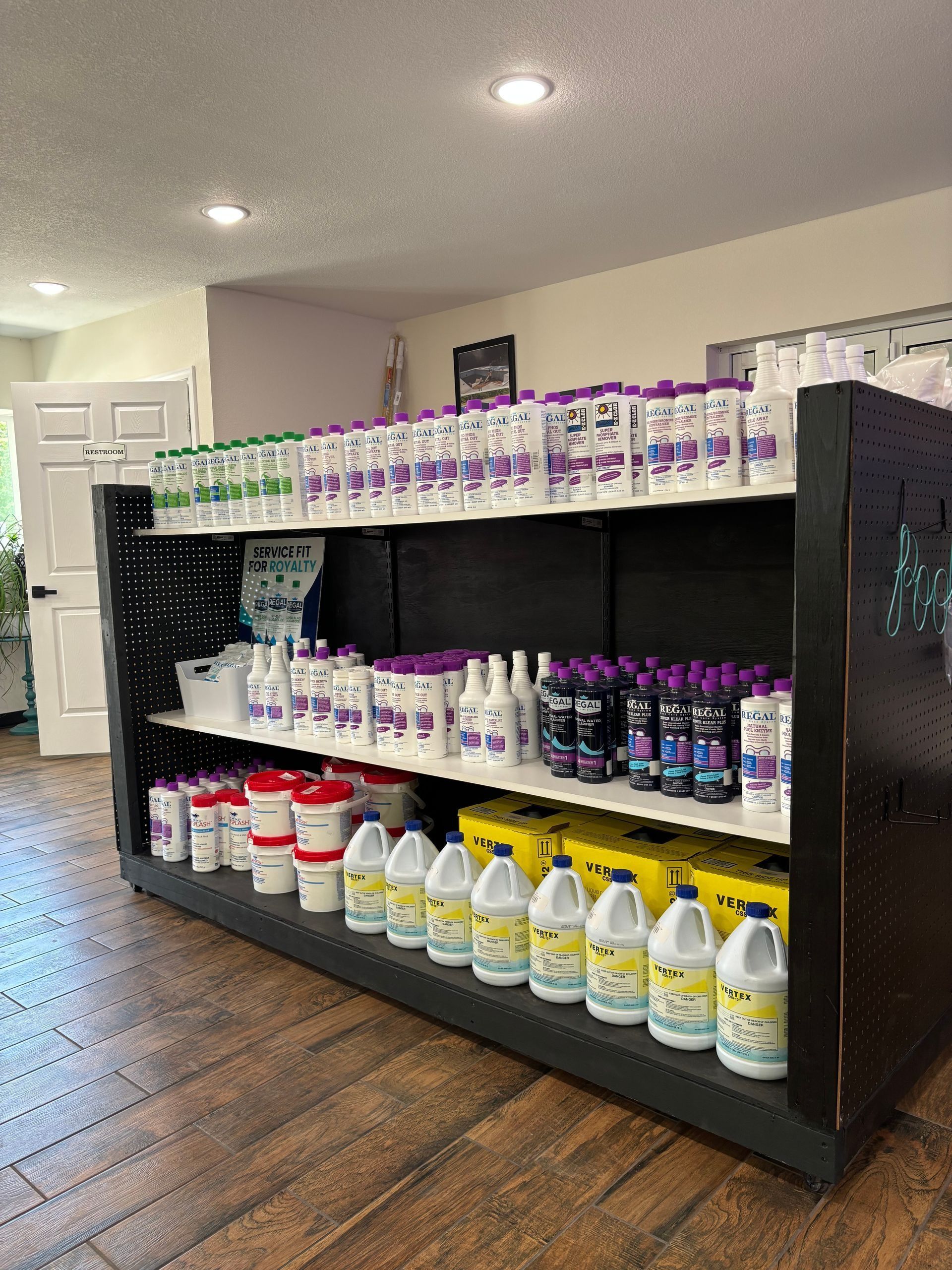 Store shelf stocked with colorful cleaning products in a bright room with wood flooring