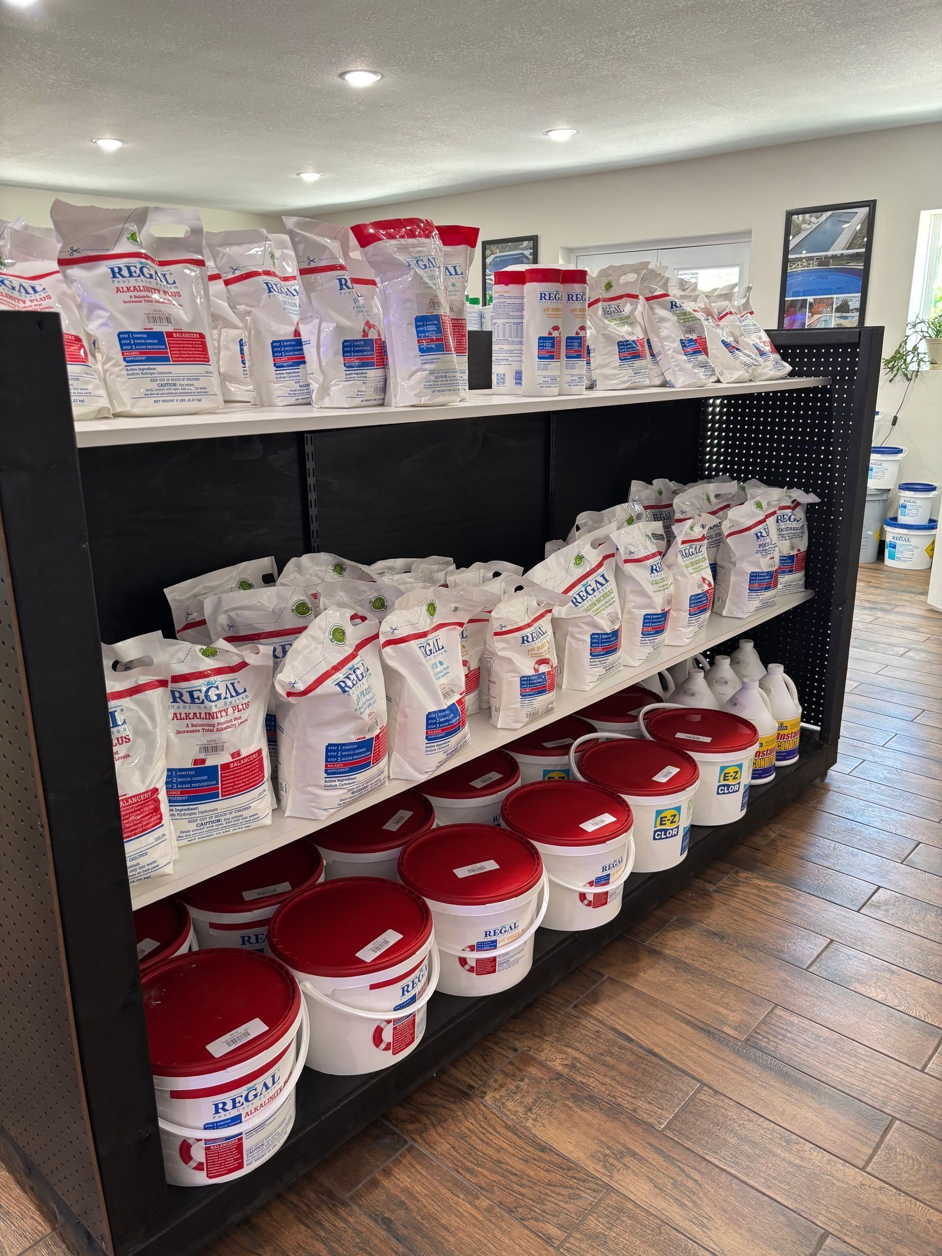 Retail aisle shelf stocked with white bags and red buckets of animal feed or supplies