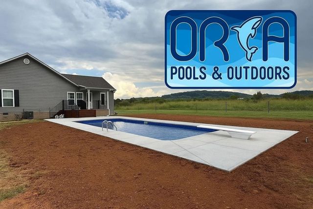 Backyard inground pool with a blue cover beside a house and ORCA Pools & Outdoors sign