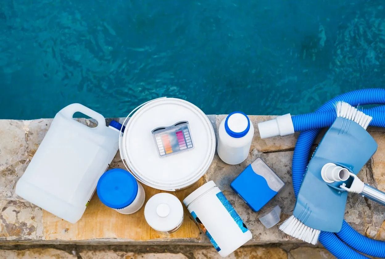 Assorted blue-and-white cleaning supplies arranged on a wooden surface against a blue background