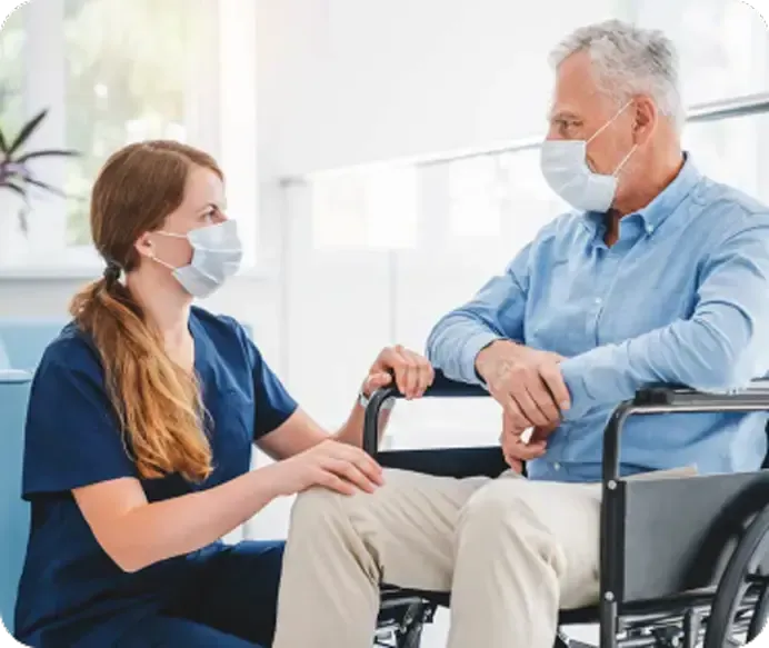Nurse in Scrubs Comforting a Person in A Wheelchair — Unique Life Services In Nelson Bay, NSW
