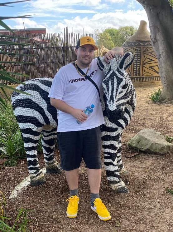 A Man Is Standing Next To A Zebra Statue — Unique Life Services In Nelson Bay, NSW