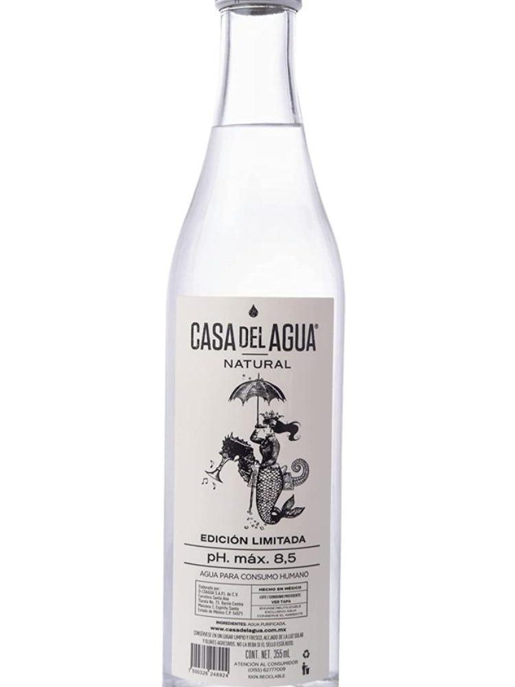 Una botella de Casa del Agua está sobre un fondo blanco.