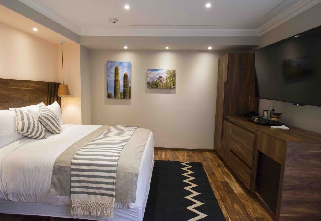 A hotel room with a large bed and a flat screen tv.