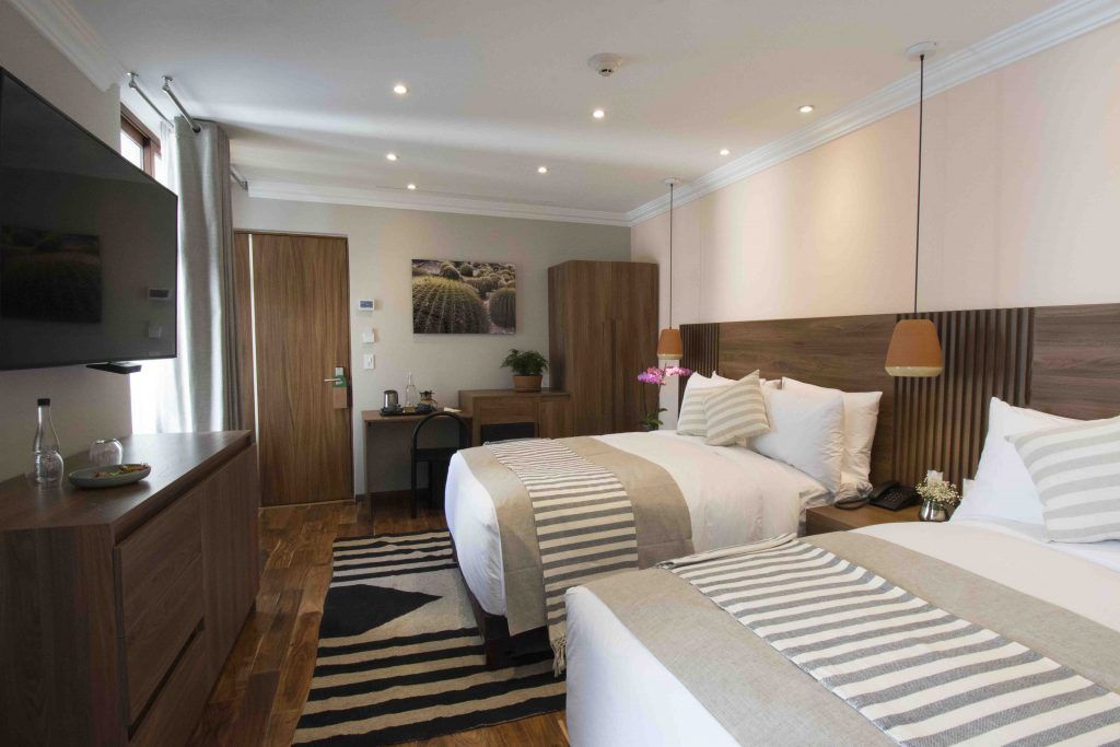 A hotel room with two beds and a flat screen tv.