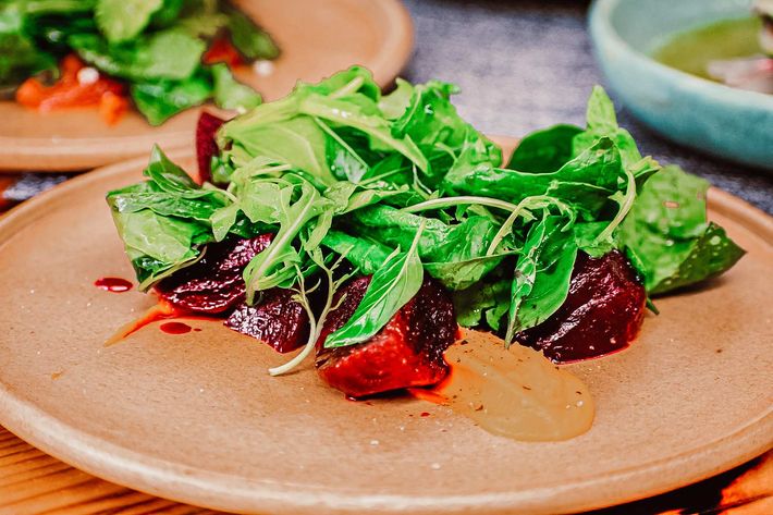 Un primer plano de una ensalada en un plato sobre una mesa.