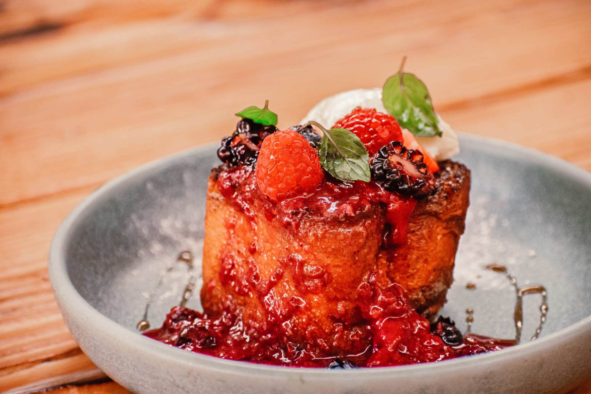 A close up of a dessert on a plate on a wooden table.