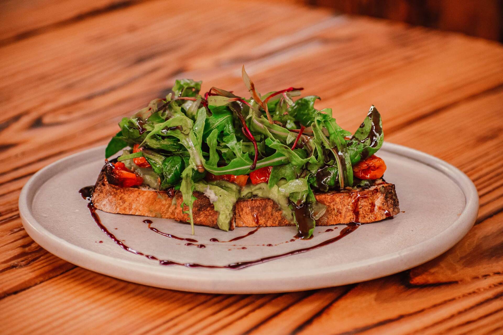 A close up of a plate of food on a wooden table.