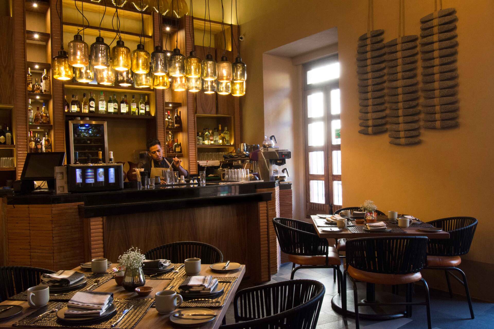 A restaurant with tables and chairs and a bar.