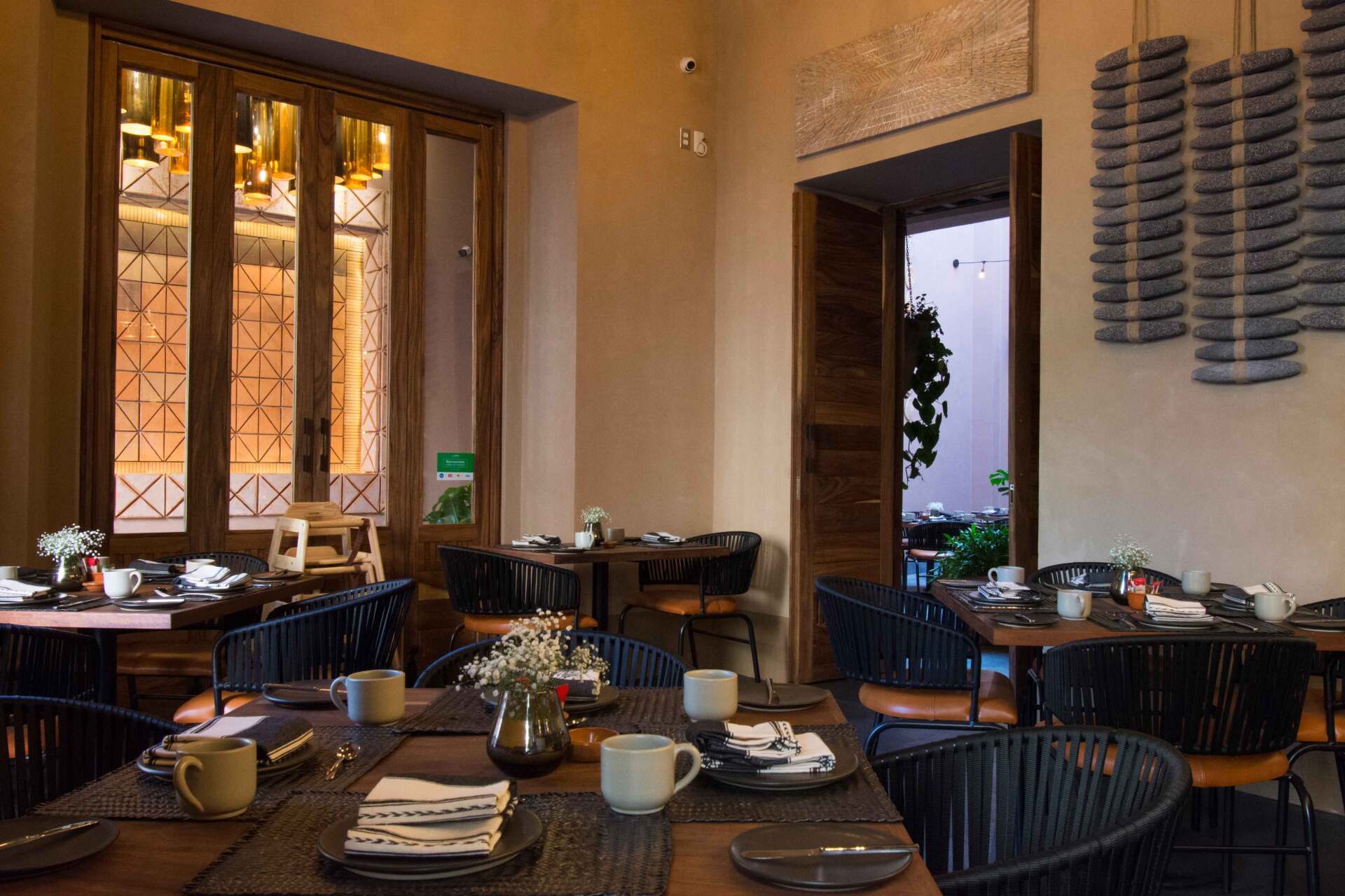 Un comedor con mesas y sillas preparadas para comer.