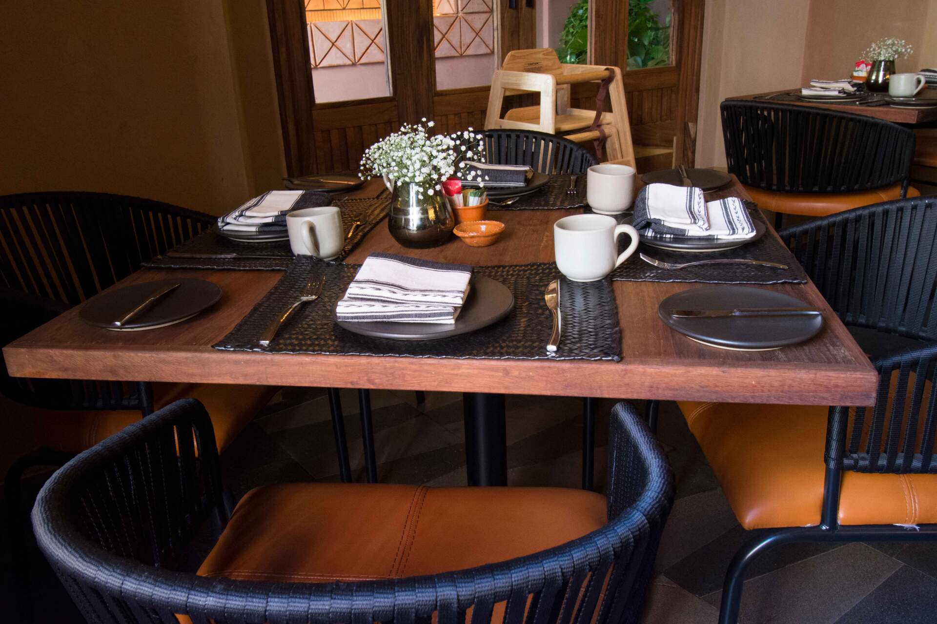 A restaurant with a table and chairs set for a meal