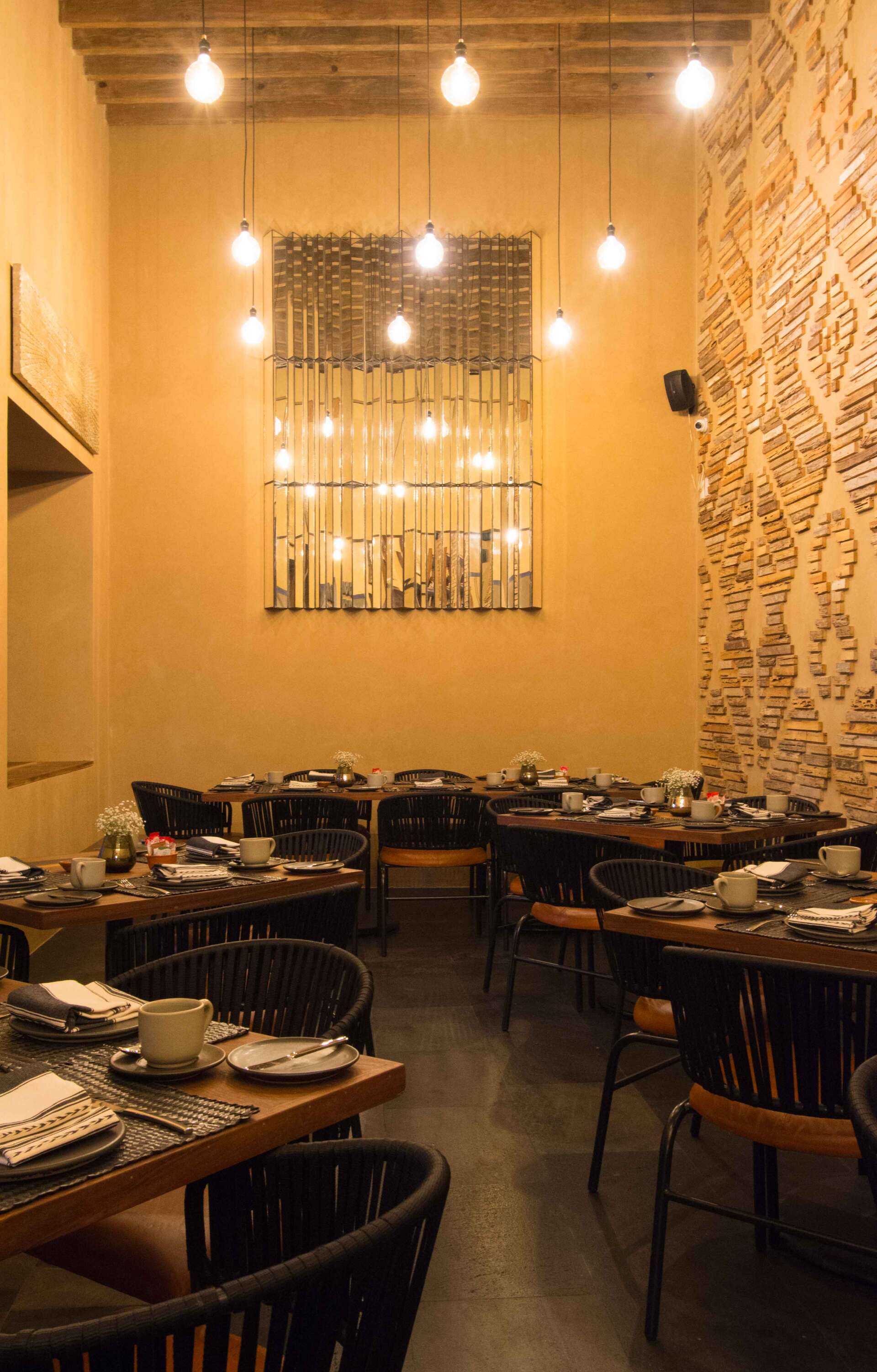 A restaurant filled with tables and chairs with plates and cups on them.