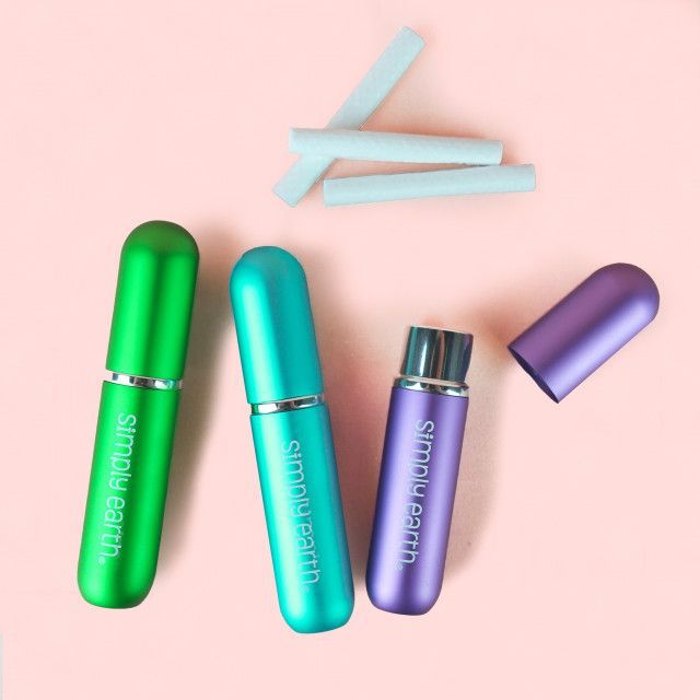 Three bottles of simply earth on a pink surface