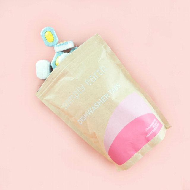 A bag of dishwasher tablets is sitting on a pink surface.
