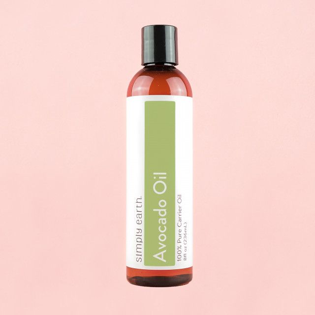 A bottle of simply earth avocado oil on a pink background
