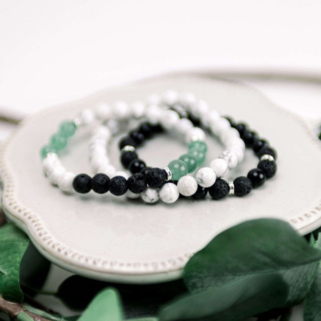 A close up of a bracelet with black and white beads on a plate.