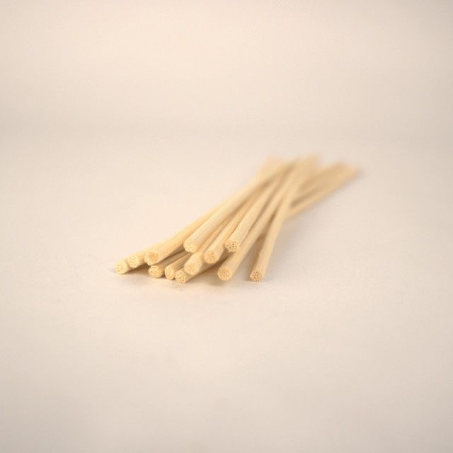 A bunch of wooden sticks are stacked on top of each other on a white surface.