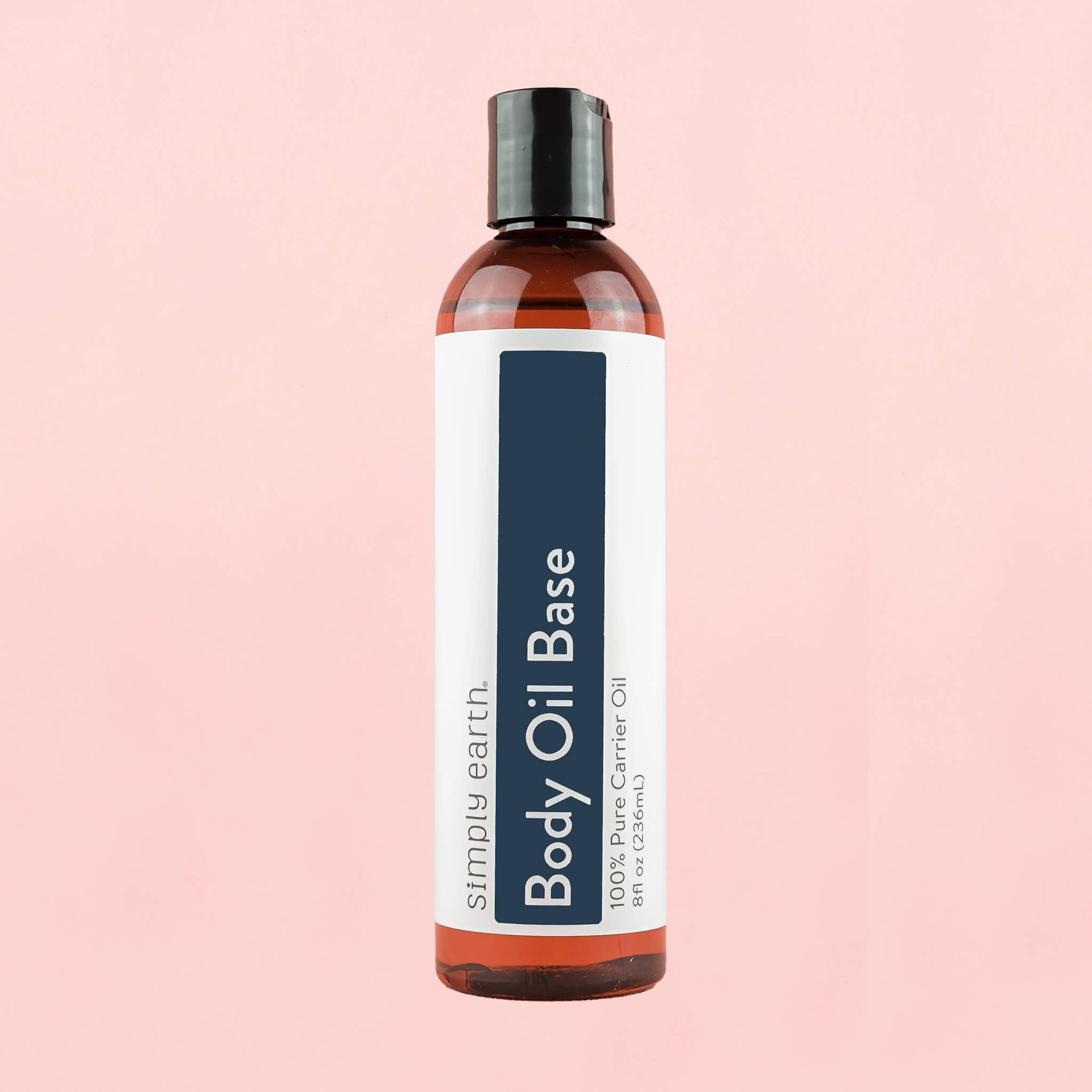 A bottle of body oil base on a pink background