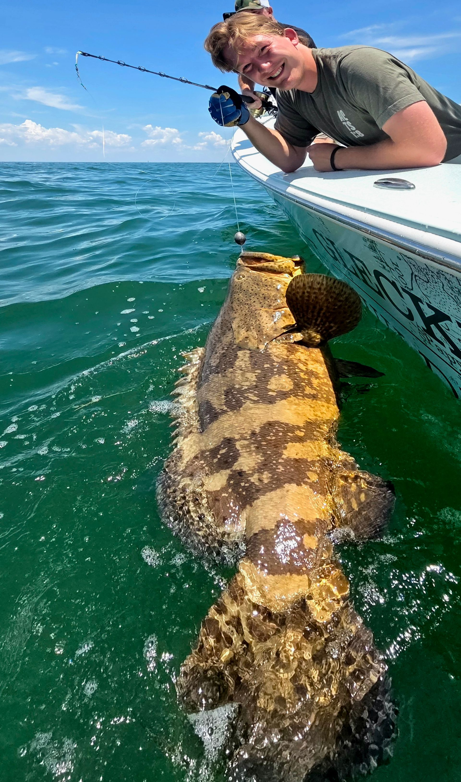 A person is holding a large fish in the water