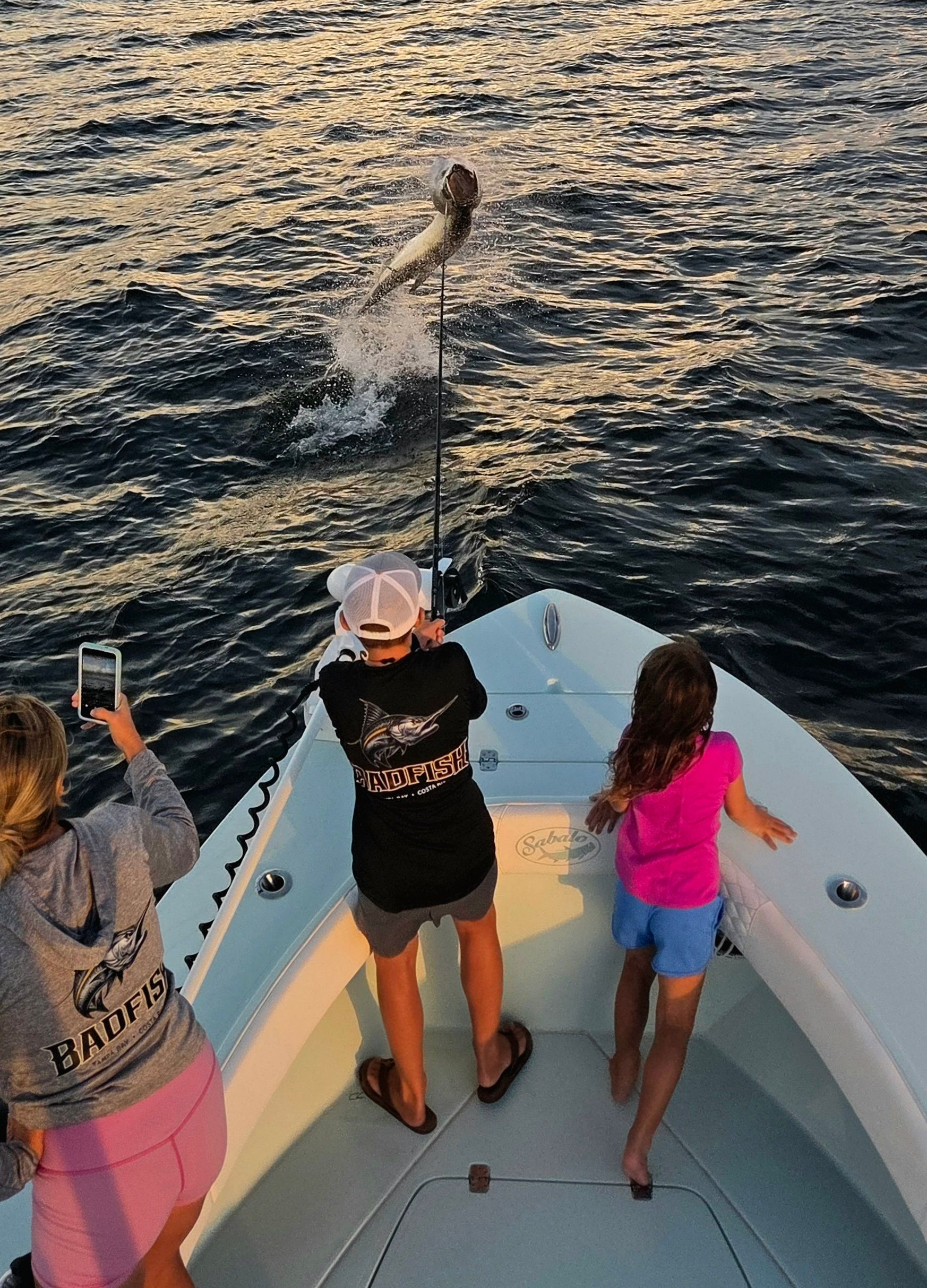 Kid catching a giant tarpon on a boat