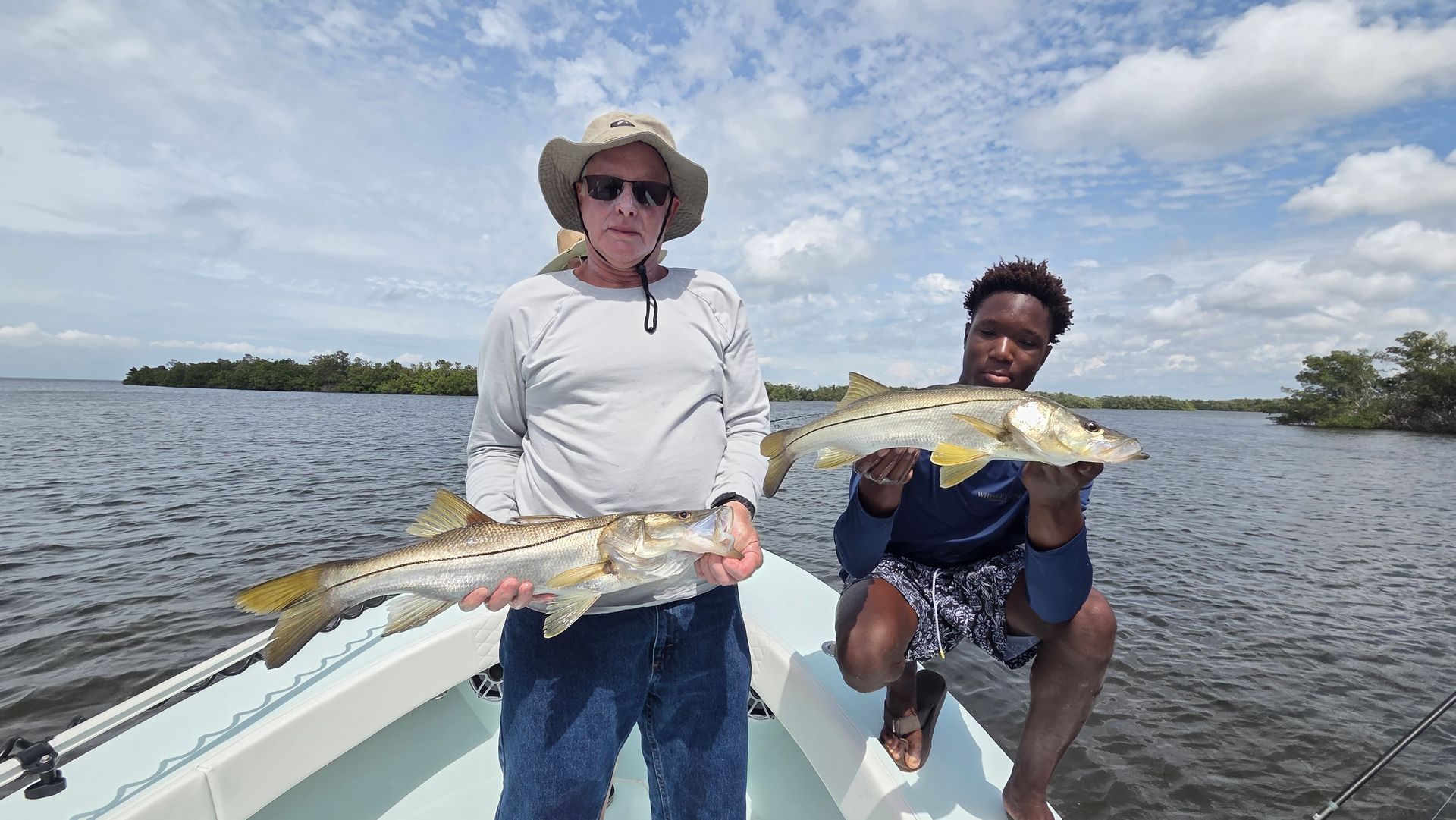 A man is holding a large red fish in his hands