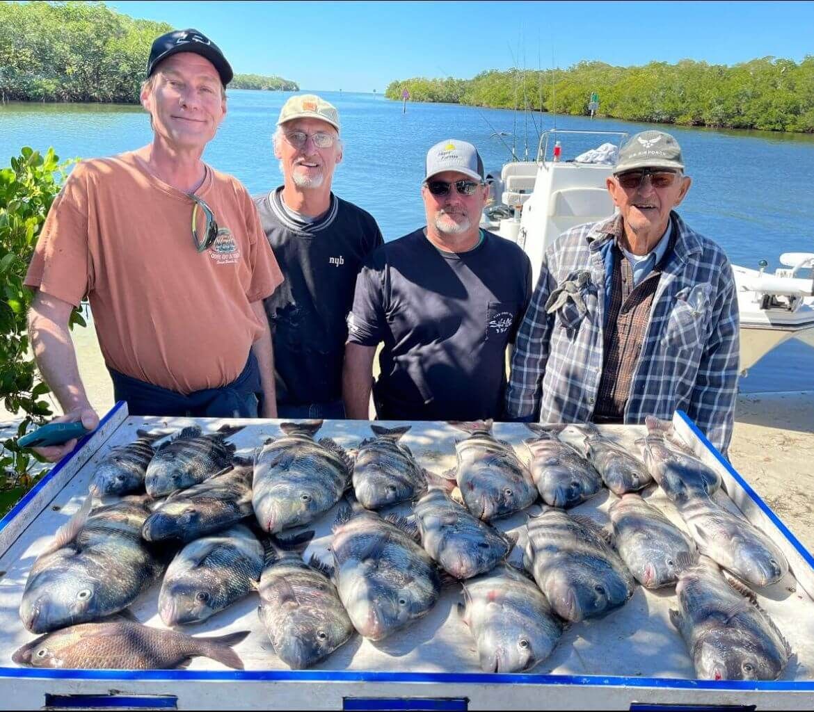 A group of men standing around a table full of fish