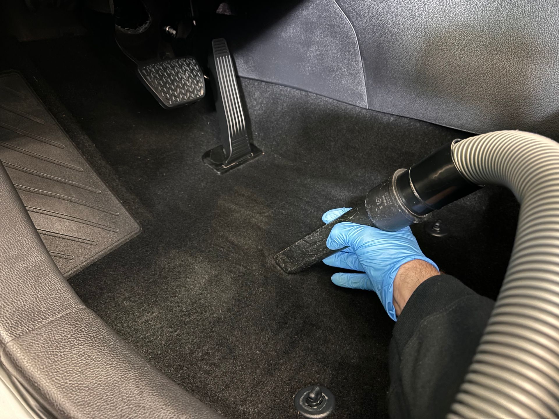 Vacuuming the interior of a vehicle at Stokes Auto Spa as part of the interior odor removal treatment. 