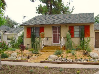 A small house with red shutters on the windows