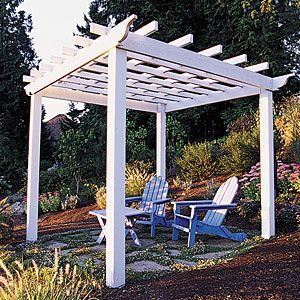A white pergola with blue chairs and a table underneath it