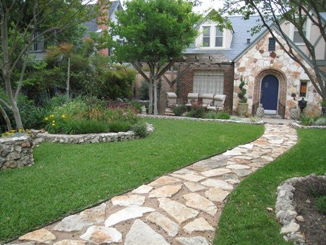 A stone walkway leads to a house with a blue door
