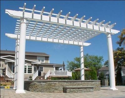 A white pergola is in front of a house