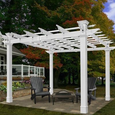 A white pergola with chairs and a table underneath it